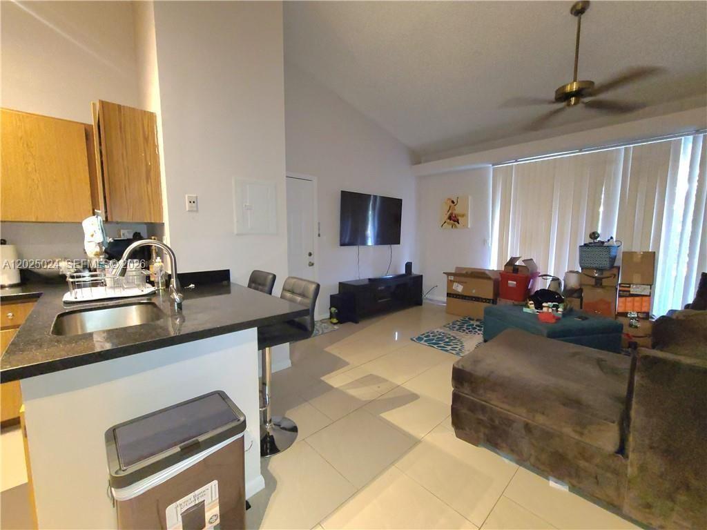 631 Lyons Road, Unit 12205 Coconut Creek, FL 33063 - Photo 4 of 14 a living room with furniture and a flat screen tv