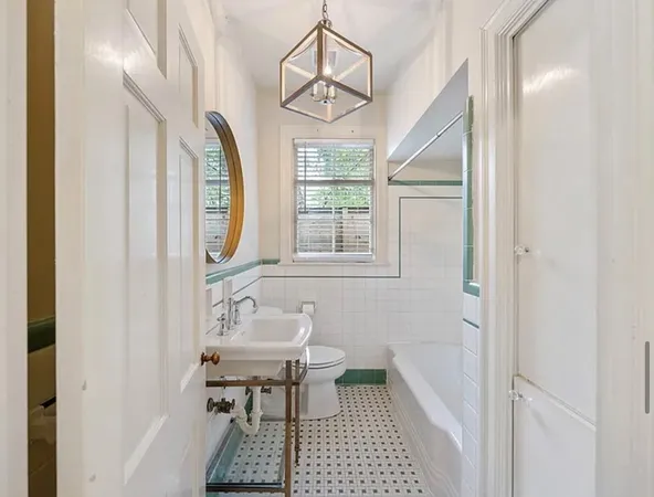 a bathroom with a sink a mirror a bathtub and next to a window