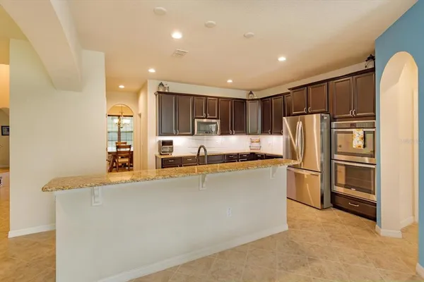a kitchen with stainless steel appliances granite countertop a refrigerator and a stove