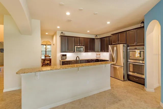a kitchen with stainless steel appliances granite countertop a refrigerator and a stove