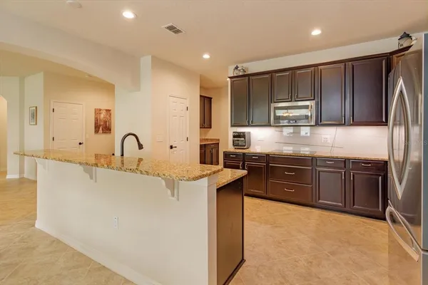 a kitchen with kitchen island granite countertop a sink stove and refrigerator