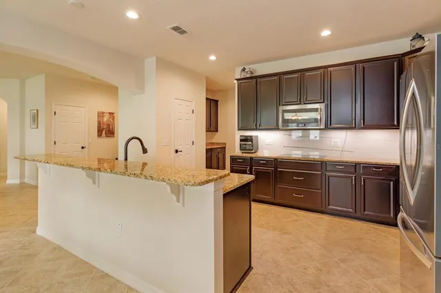 a kitchen with kitchen island granite countertop a sink stove and refrigerator