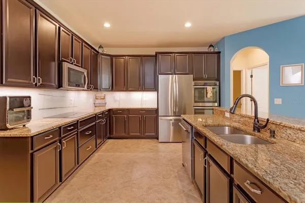 a kitchen with stainless steel appliances granite countertop a sink stove and refrigerator