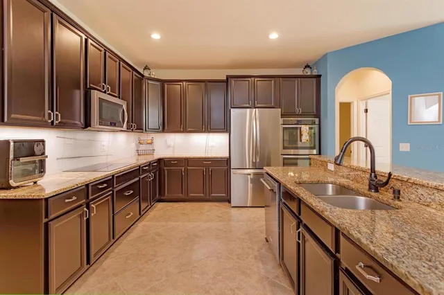 a kitchen with stainless steel appliances granite countertop a sink stove and refrigerator