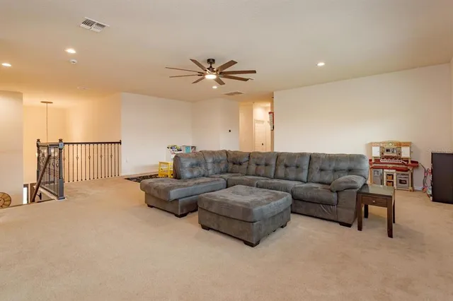 a living room with furniture and a ceiling fan