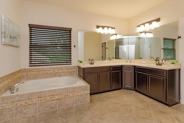 a spacious bathroom with a bathtub sink and mirror