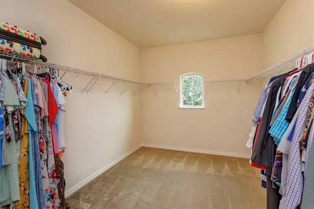 a view of walk in closet with clothes and shoes