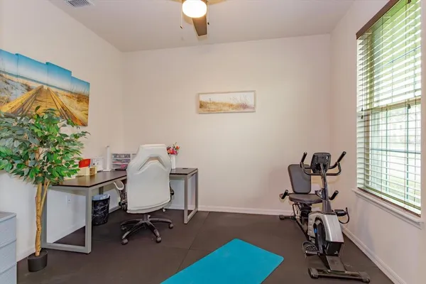 a view of a workspace with furniture and a window