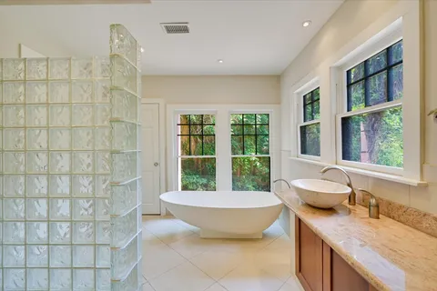 a spacious bathroom with a granite countertop tub a sink and a window