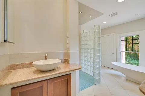 a bathroom with a granite countertop sink a toilet and shower
