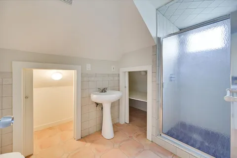 an empty room with a windows and chandelier fan