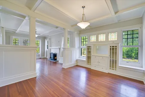 a view of empty room with wooden floor and fireplace