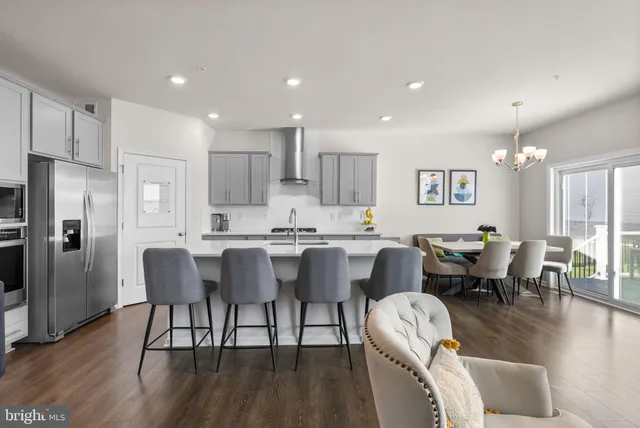 a kitchen with stainless steel appliances a sink a stove a refrigerator a counter space and cabinets