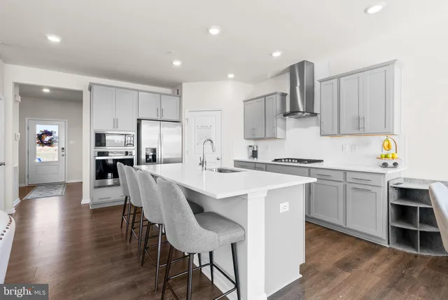a kitchen with counter top space a sink a stove and wooden cabinets