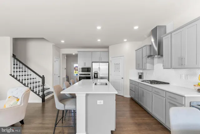 a kitchen with stainless steel appliances granite countertop a refrigerator and a stove top oven