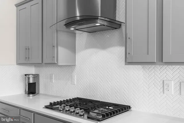 a kitchen with stainless steel appliances granite countertop a dining table chairs and a refrigerator