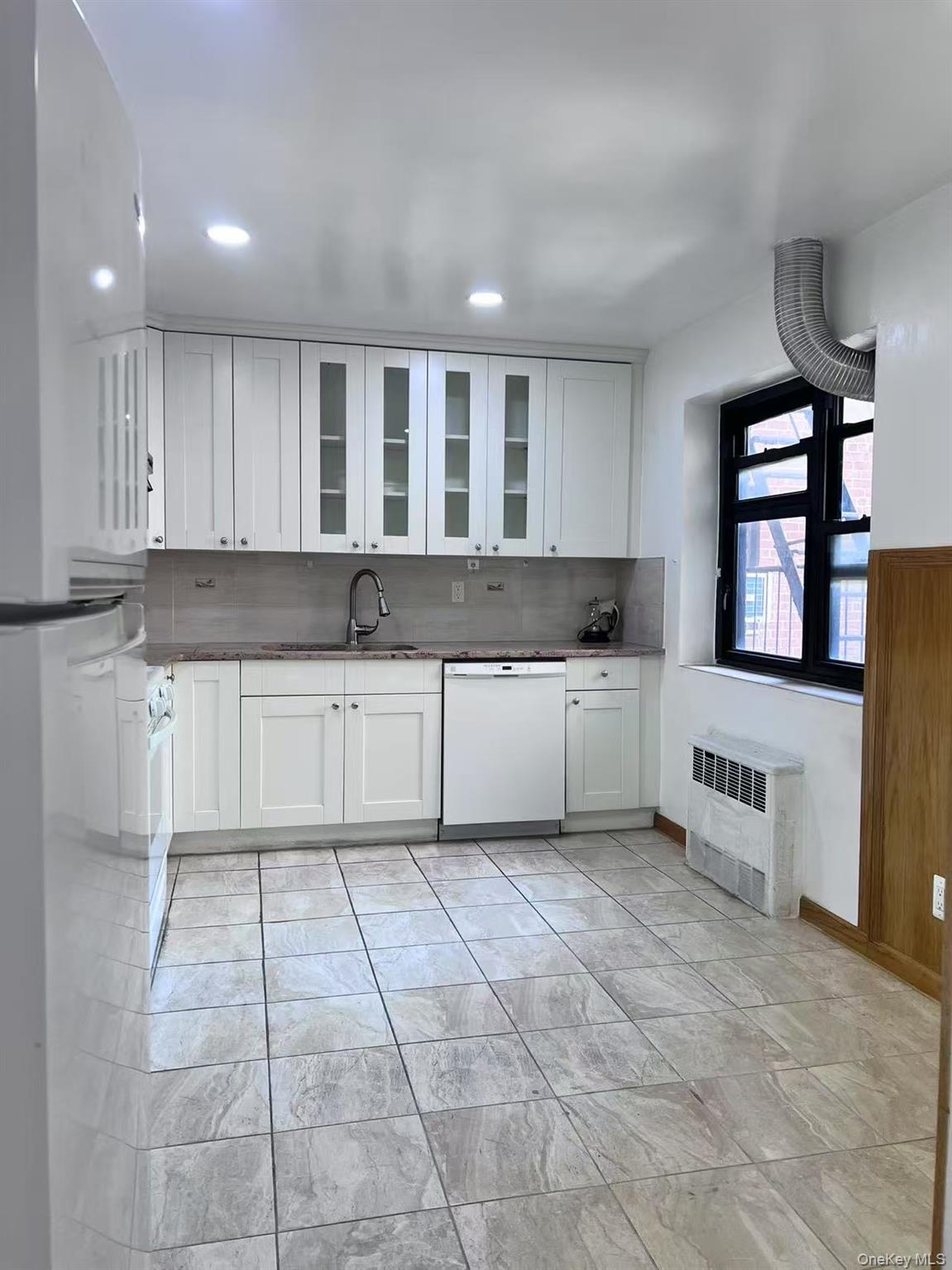 138-20 31st Road, Unit 2C Queens, NY 11354 - Photo 2 of 6 a kitchen with granite countertop a sink a window and cabinets