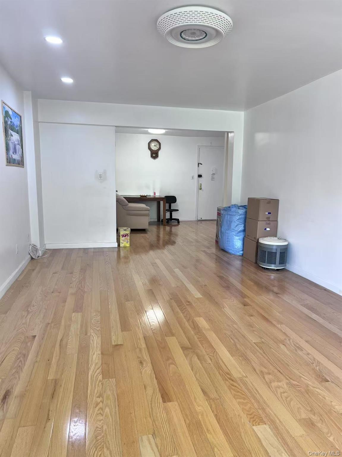 138-20 31st Road, Unit 2C Queens, NY 11354 - Photo 4 of 6 a room with wooden floor and furniture