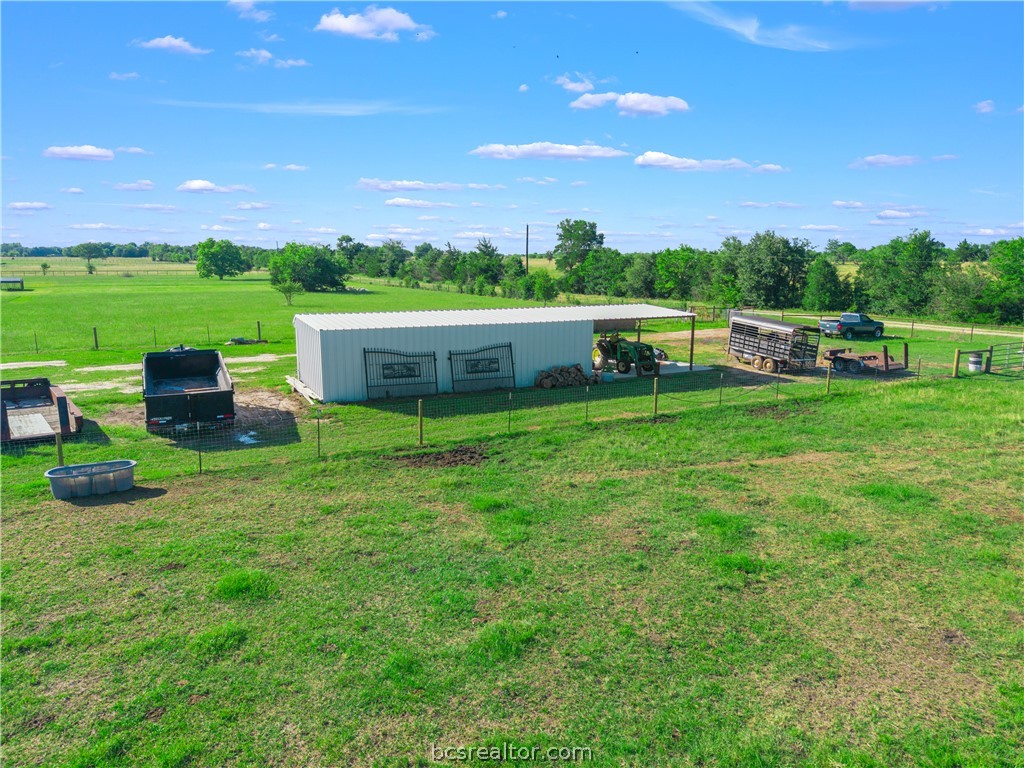 13504 Hudson Farms Road Hearne, TX 77859 - Photo 33 of 48 Concrete Pad Extension: The right side features a solid concrete foundation (perfect for a workshop area, clean storage, or grooming station), while the left side offers covered ground parking.