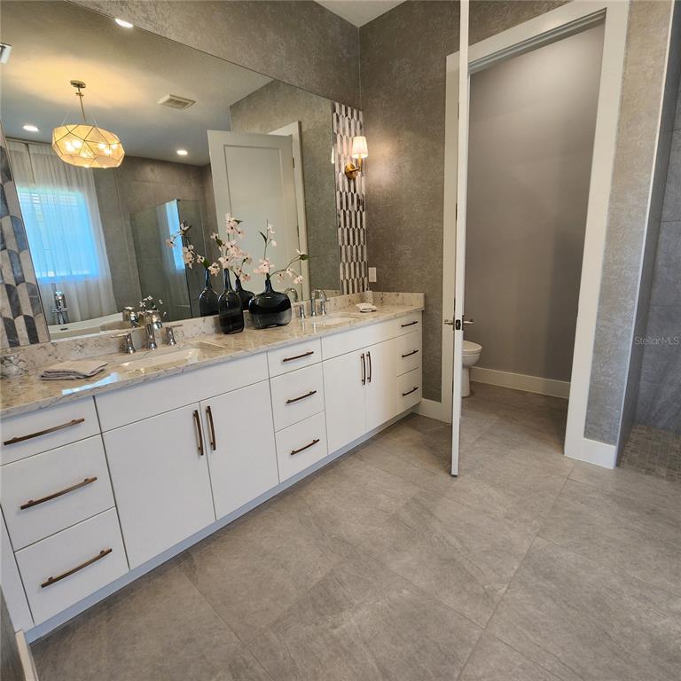 512 Blue Shell Loop Sarasota, FL 34240 - Photo 8 of 15 a spacious bathroom with a double vanity sink and a mirror