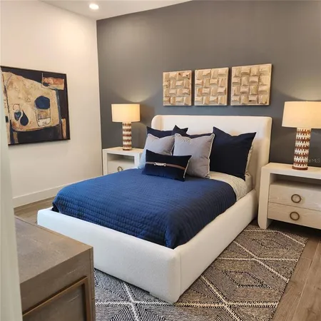 a bedroom with a bed and wooden floor