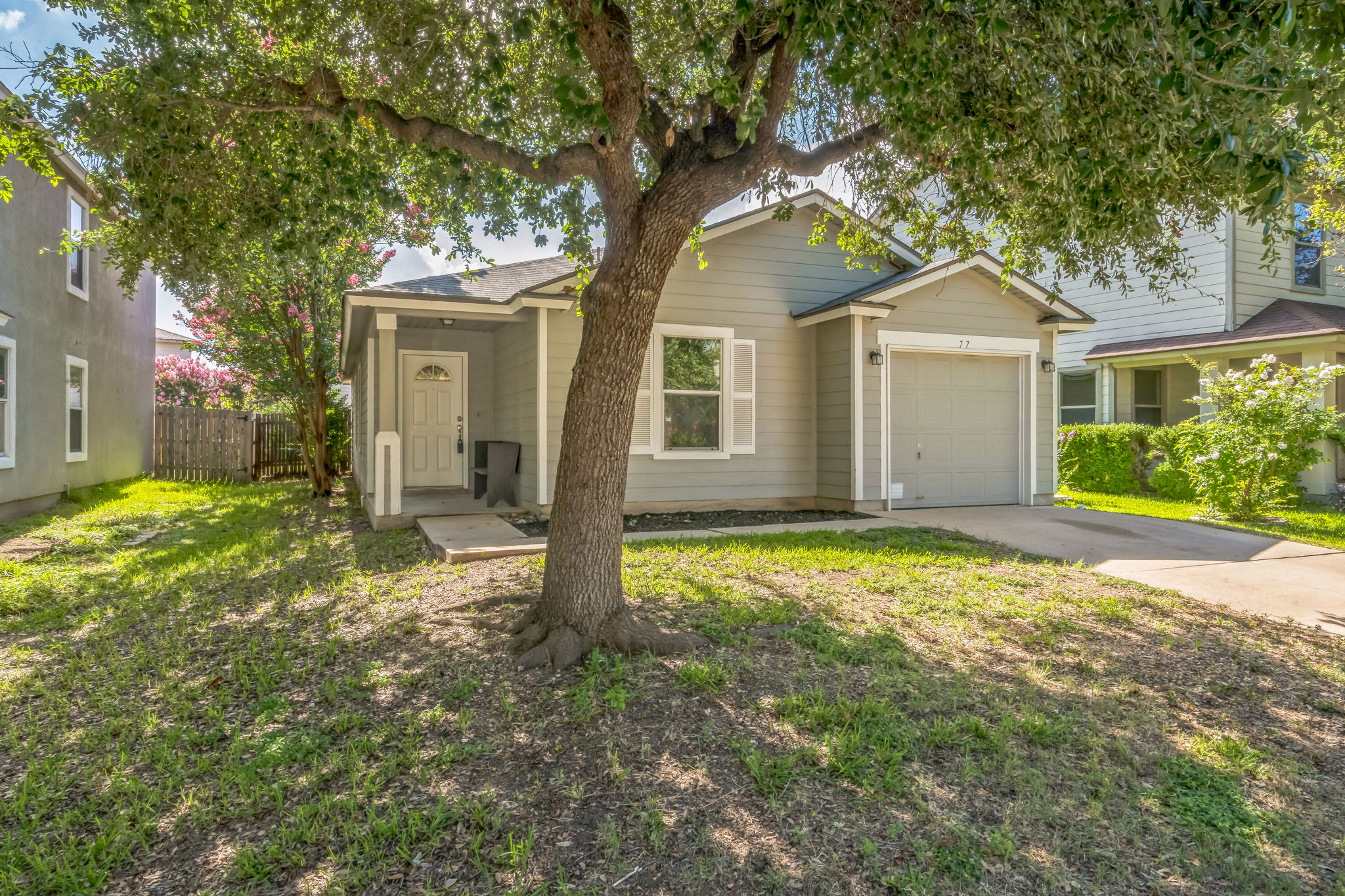 77 Jan Lane Georgetown, TX 78626 - Photo 6 of 16 A welcoming front exterior showcasing a single-story home with a neat driveway and mature shade trees.