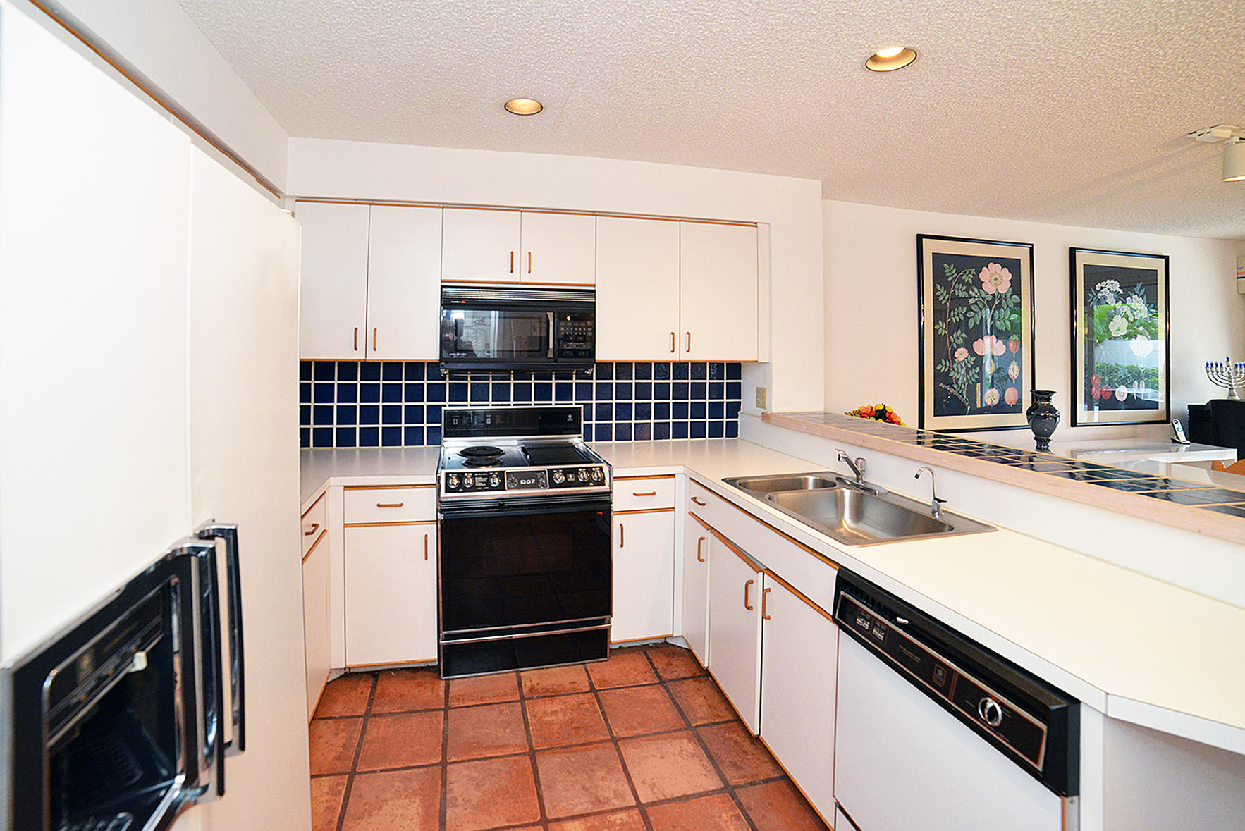 2168 Northwest 53rd Street Boca Raton, FL 33496 - Photo 11 of 31 a kitchen with a sink stove top oven and cabinets