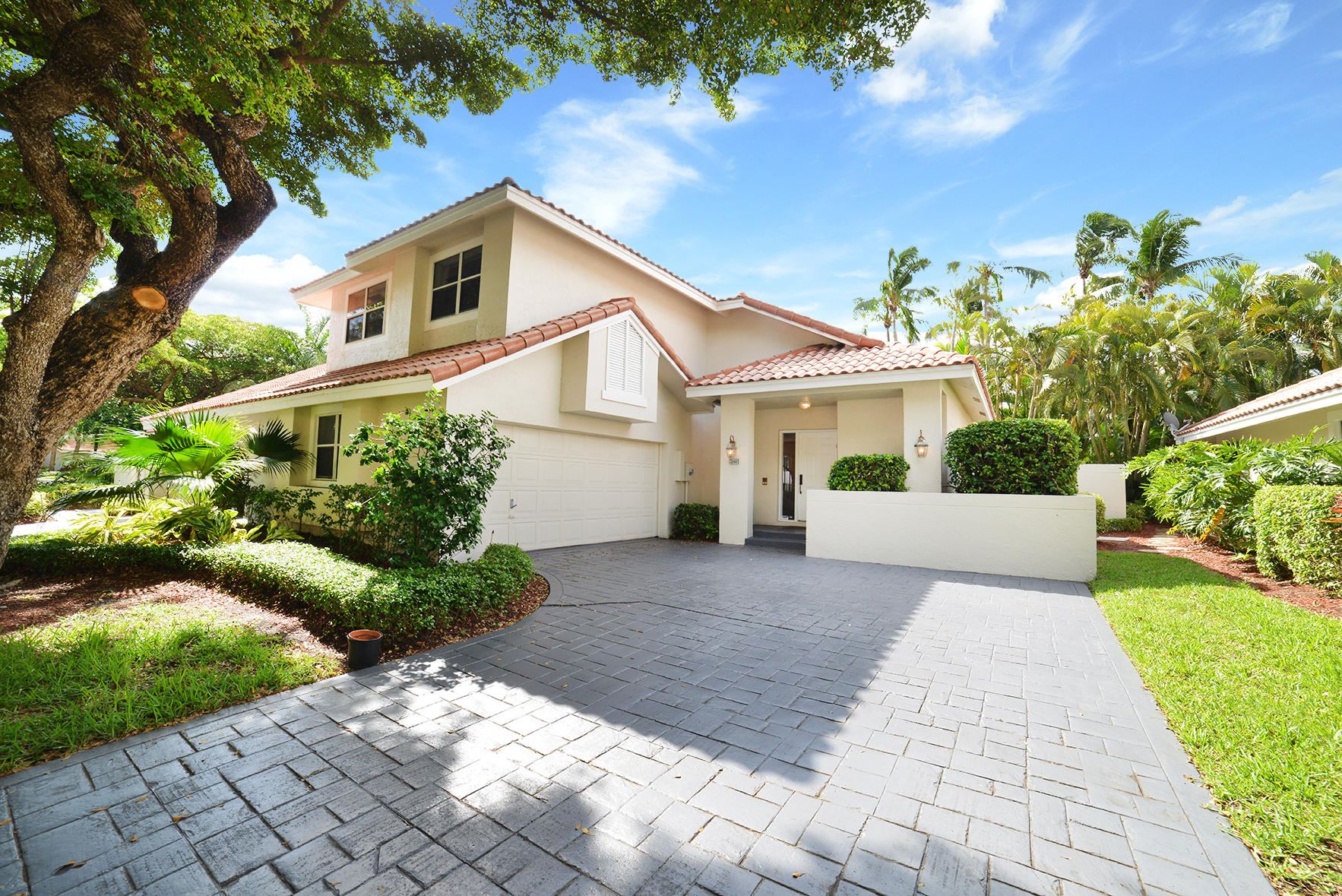 2168 Northwest 53rd Street Boca Raton, FL 33496 - Photo 2 of 31 a front view of a house with a yard and a garden