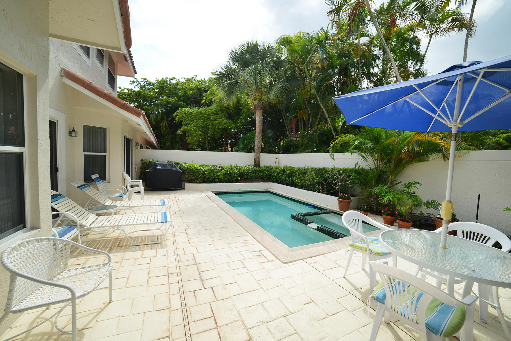 2168 Northwest 53rd Street Boca Raton, FL 33496 - Photo 26 of 31 a view of a chair and tables in the backyard of the house