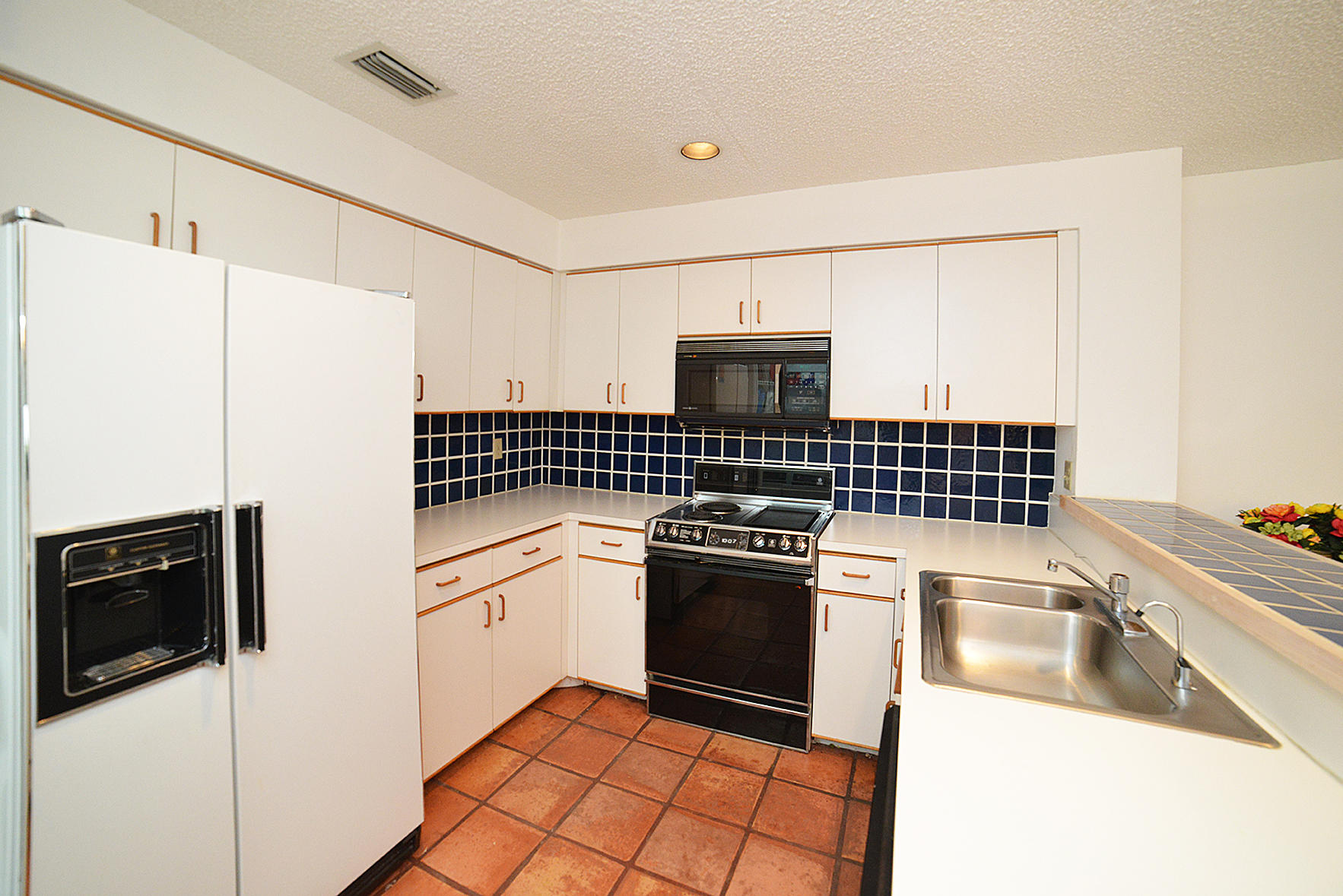 2168 Northwest 53rd Street Boca Raton, FL 33496 - Photo 10 of 31 a kitchen with granite countertop a refrigerator stove and sink
