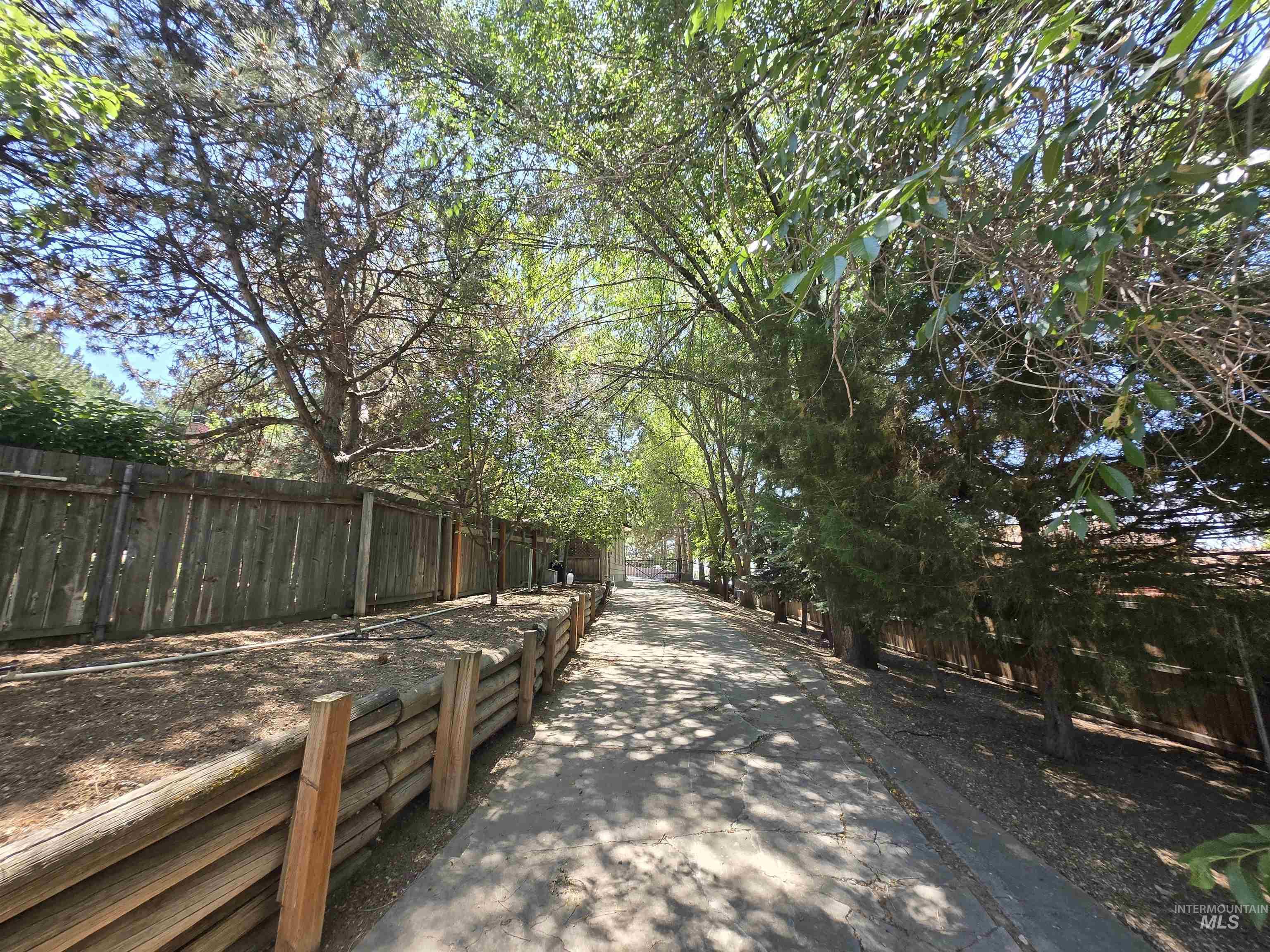 12050 West Hidden Valley Rim Road Boise, ID 83709 - Photo 23 of 39 Paved pathway bordered by mature trees and a wood fence