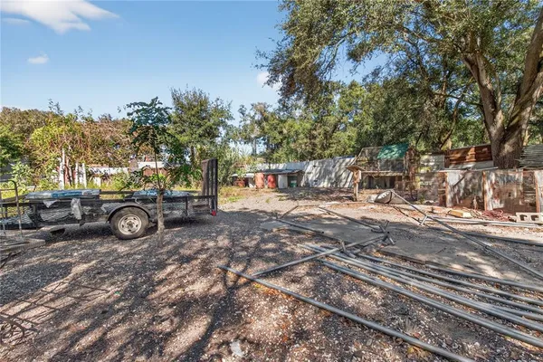 a backyard of a house with table and chairs and a large tree