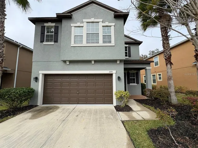 a front view of a house with a yard and garage