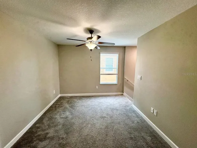 an empty room with a ceiling fan and a window