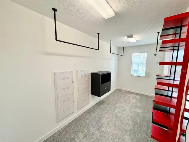 a view of an empty room with cabinet and a window