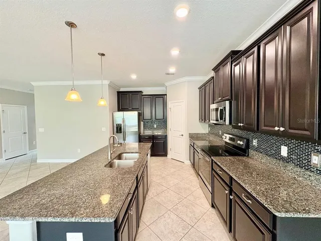 a large kitchen with kitchen island granite countertop a large counter top and chairs