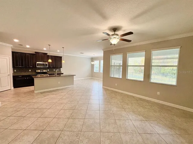 a view of an empty room with a kitchen stove and a window
