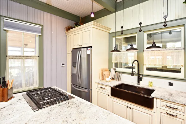 a kitchen with granite countertop a sink stainless steel appliances and white cabinets
