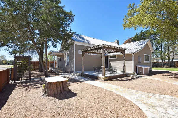 a view of a backyard with a small cabin and wooden fence