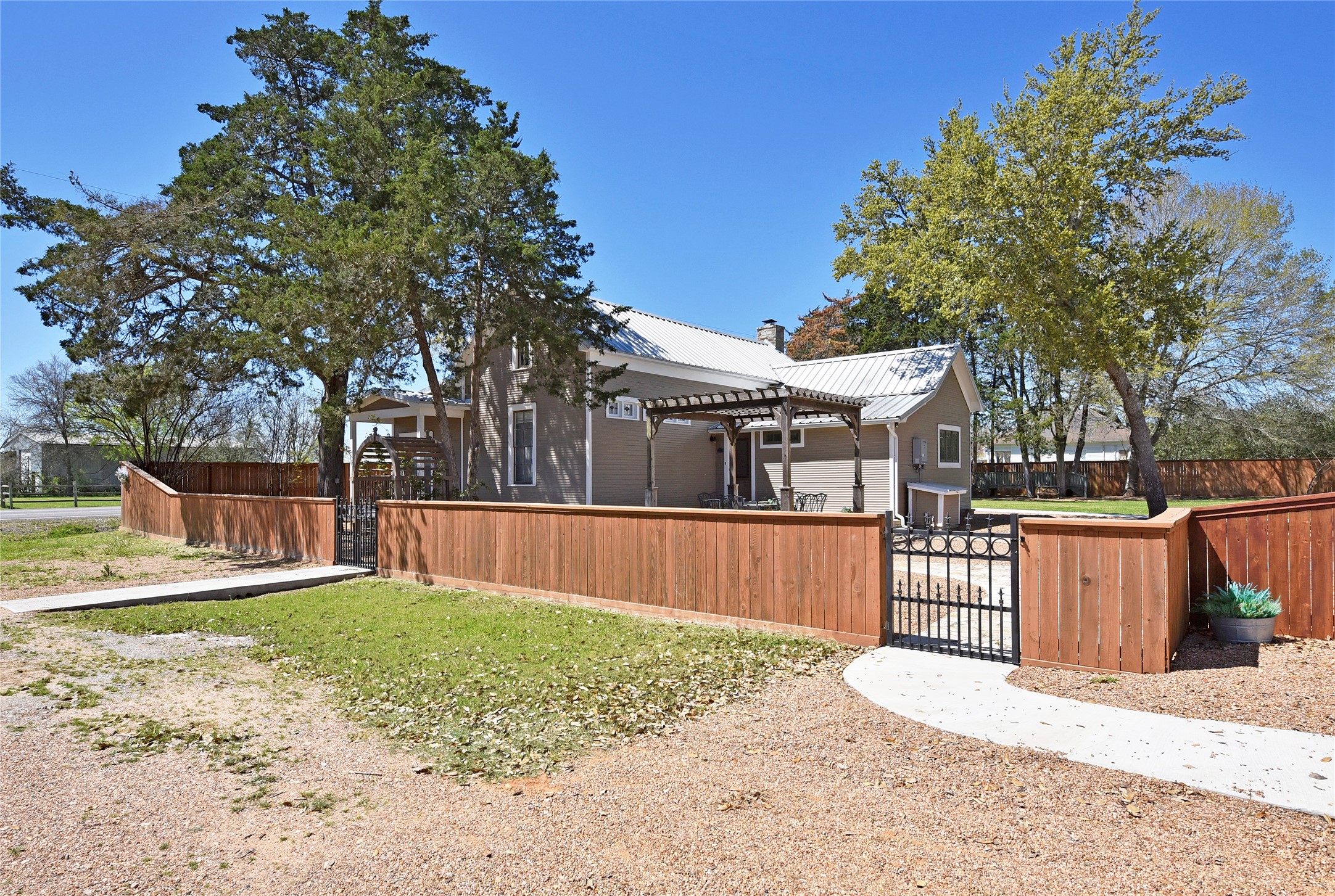 315 Cedar Street New Ulm, TX 78950 - Photo 30 of 50 a view of a backyard with a small cabin and wooden fence