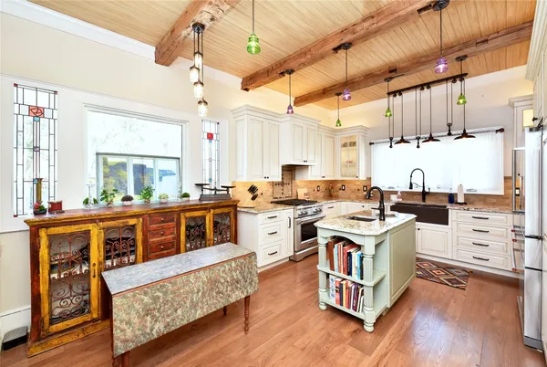 a kitchen with granite countertop a stove a sink dishwasher and a refrigerator with wooden floor