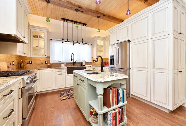 a kitchen with granite countertop a sink stainless steel appliances and cabinets