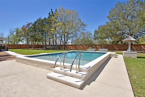 a swimming pool with outdoor seating and yard