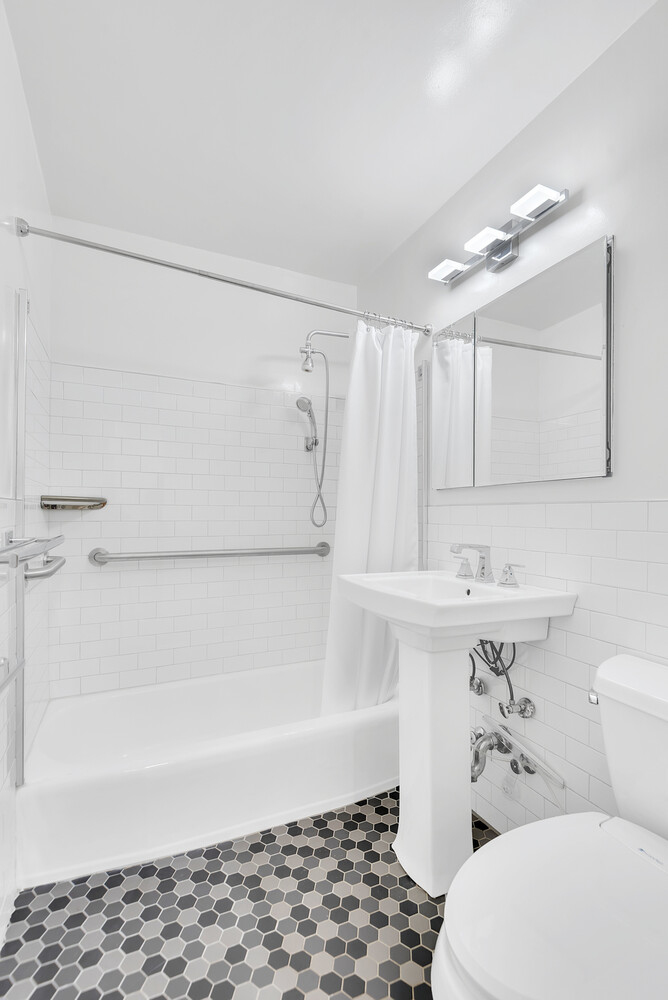 5700 Arlington Avenue, Unit 22R Bronx, NY 10471 - Photo 10 of 14 a bathroom with a sink a toilet and shower