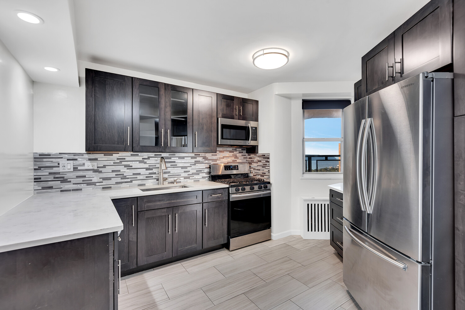 5700 Arlington Avenue, Unit 22R Bronx, NY 10471 - Photo 11 of 14 a modern kitchen with stainless steel appliances and a refrigerator