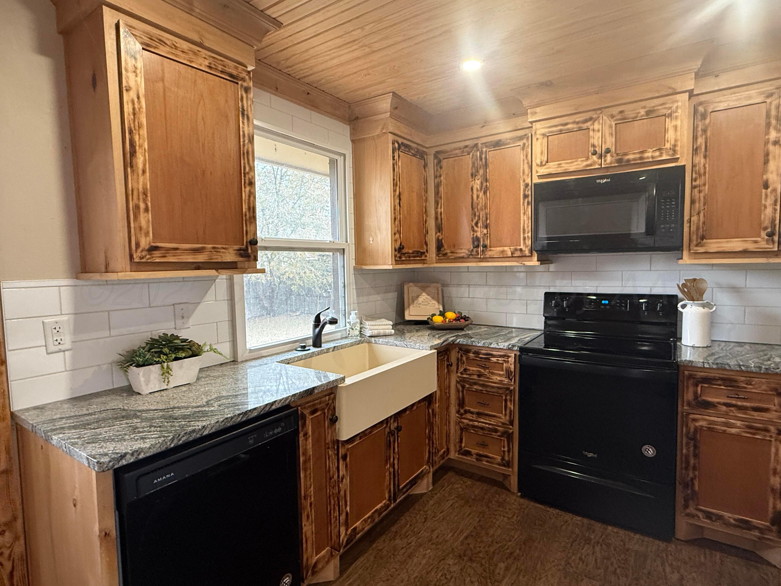 701 East 3rd Street Dumas, TX 79029 - Photo 4 of 14 a kitchen with a sink and a stove top oven