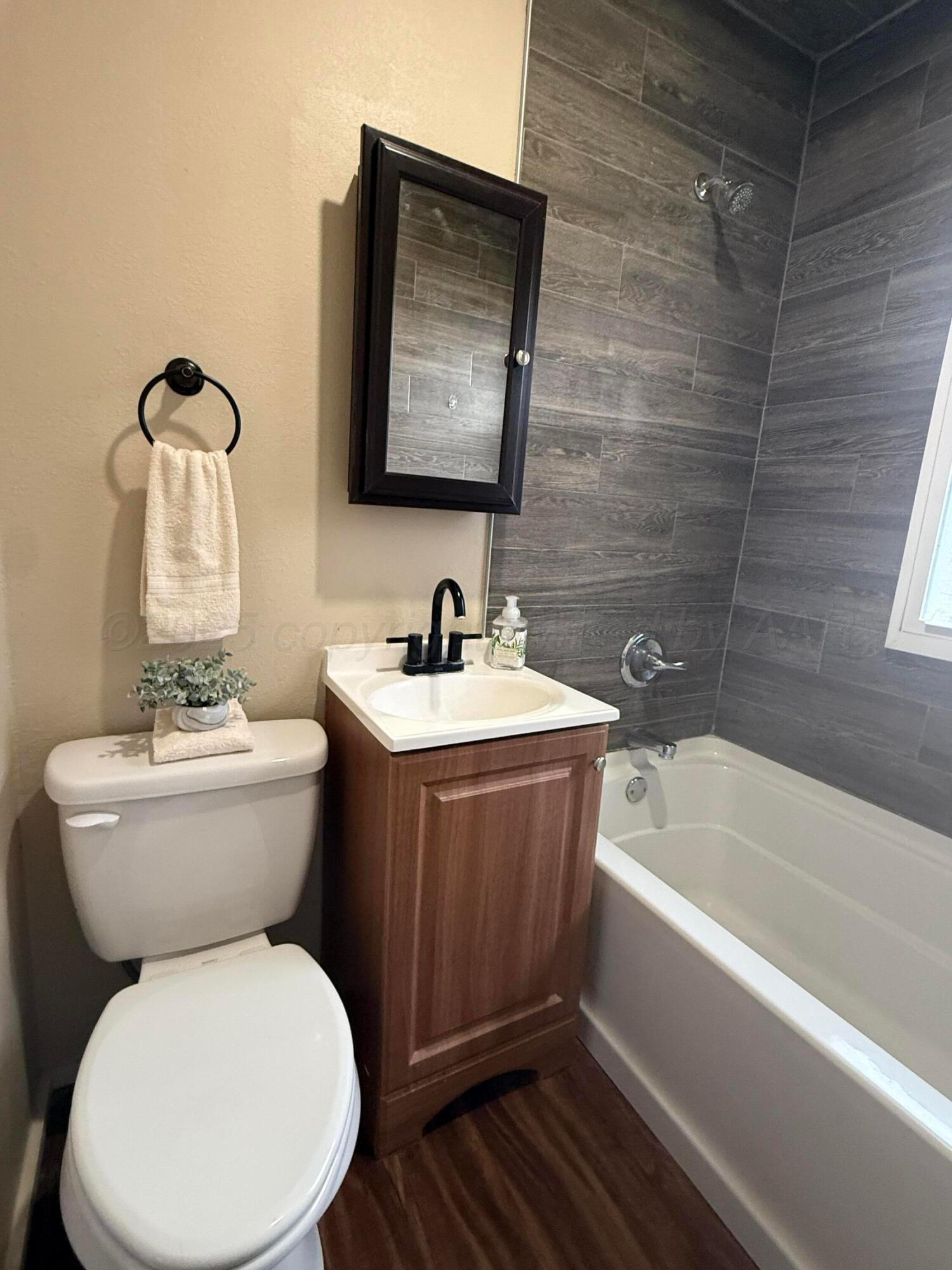 701 East 3rd Street Dumas, TX 79029 - Photo 9 of 14 a bathroom with a toilet sink and mirror