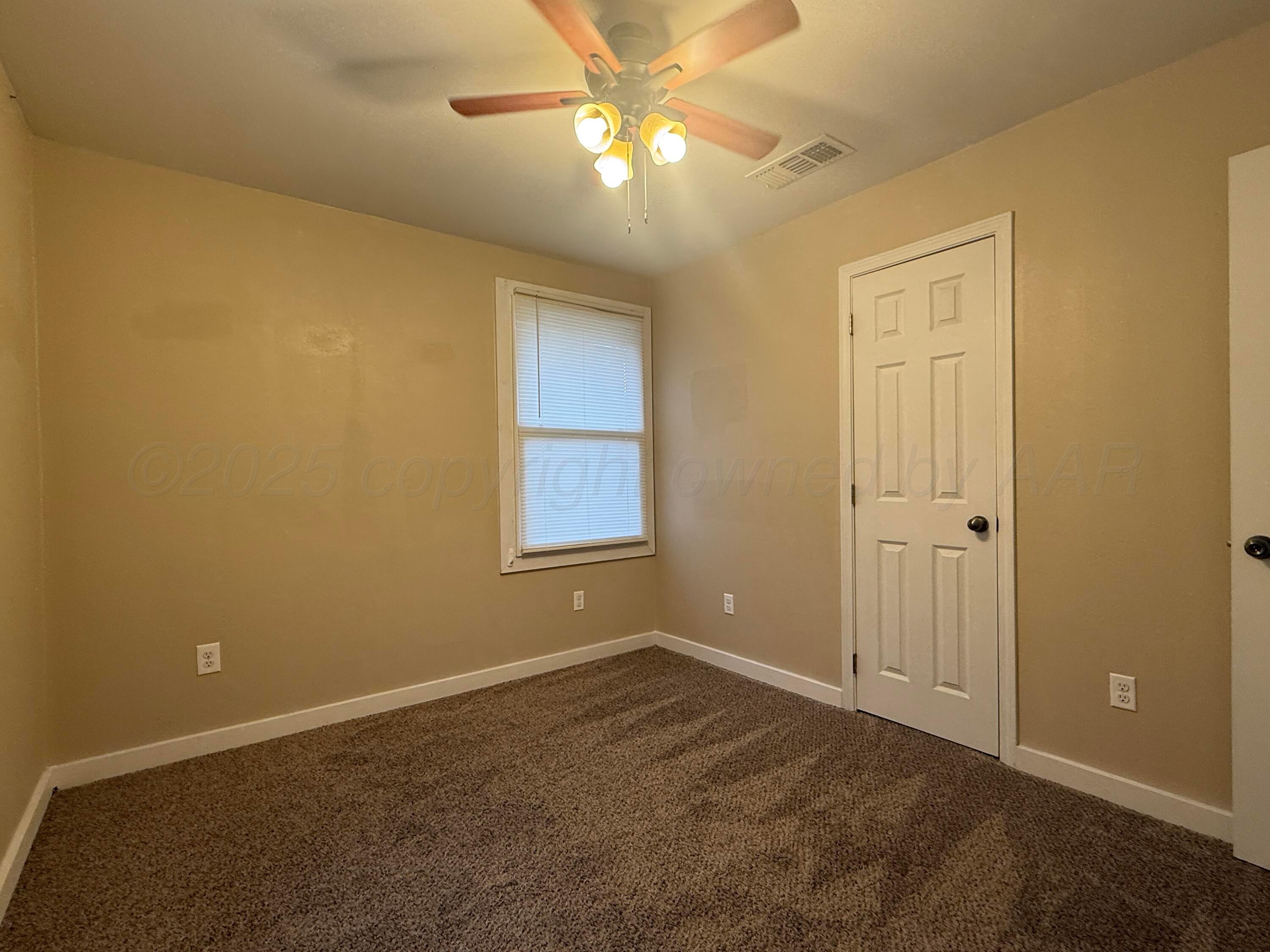 701 East 3rd Street Dumas, TX 79029 - Photo 10 of 14 a view of an empty room and chandelier fan
