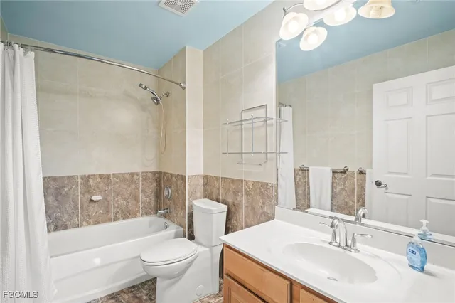 a bathroom with a sink a toilet a mirror a bathtub and shower