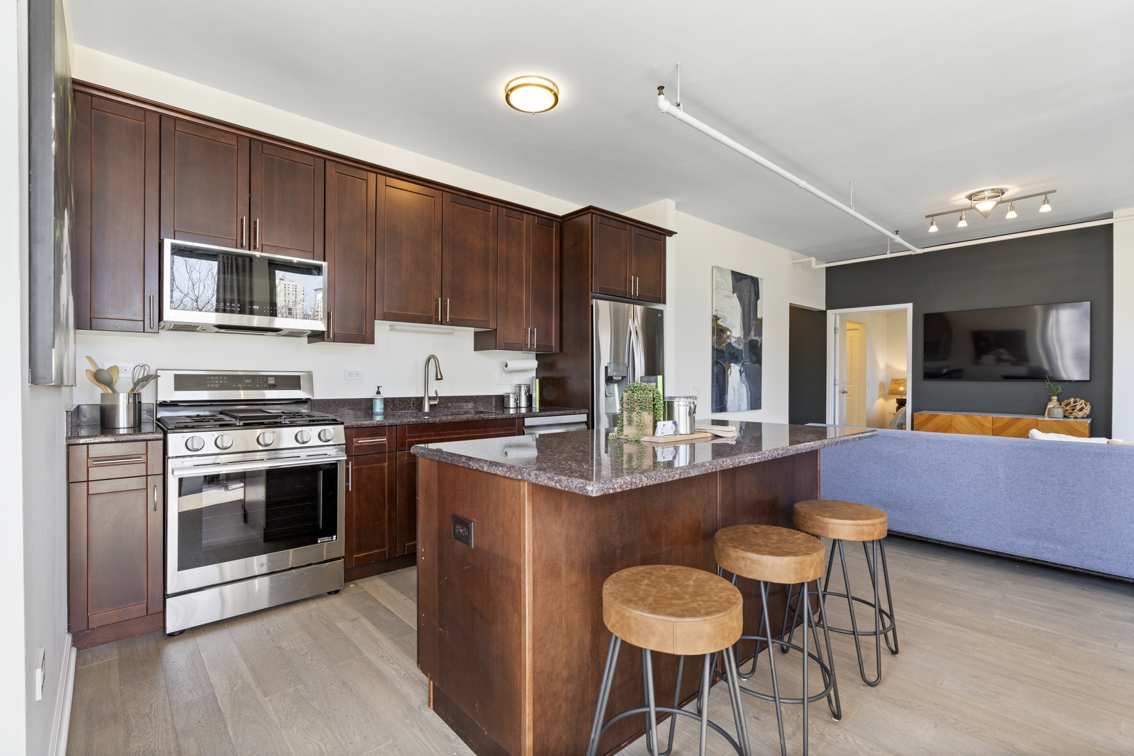 437 West Division Street, Unit 310 Chicago, IL 60610 - Photo 11 of 23 a kitchen with stainless steel appliances granite countertop a stove top oven a sink dishwasher a dining table and chairs with wooden floor